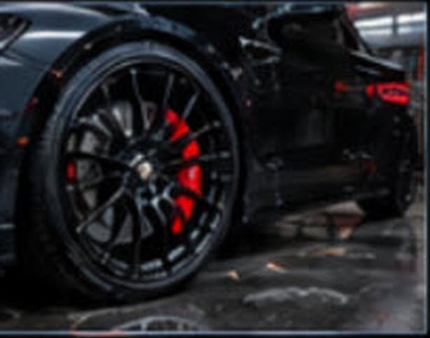 Black finish wheel with red brake caliper on a sports car